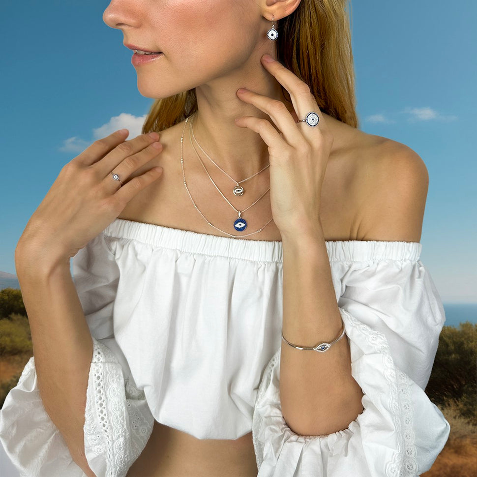 Model wearing Evil Eye motif jewelry inspired by centuries of tradition in the Greek islands.